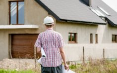 Mann steht vor Rohbau 