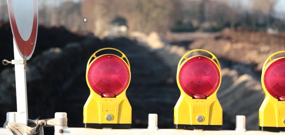 Durchfahrt verboten Schild neben Straßensperre mit Baustellen-Warnlampen