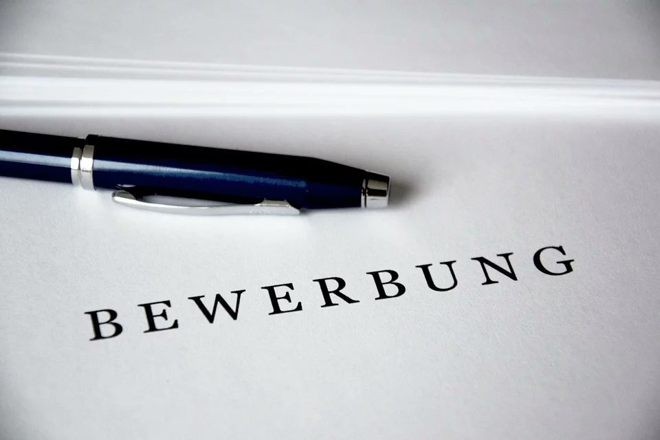 Bewerbung auf der ein blauer Stift liegt