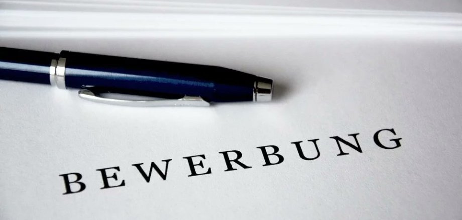 Bewerbung auf der ein blauer Stift liegt