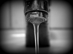 Laufender Wasserhahn Nahaufnahme von vorne, minimal laufender Wasserhahn